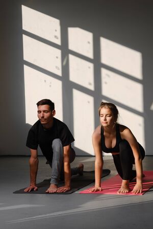 Fitness, man and woman training yoga. Young couple makes exercise