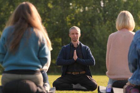 A yoga teacher shows an exercise for a group of beginners.の写真素材
