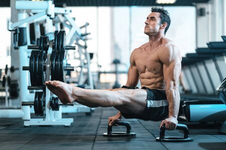 A man with a naked torso makes a bar-corner, standing on his hands. The concept of freedom and...