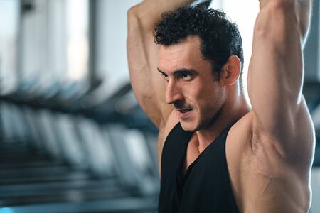 Very power athletic guy, execute exercise in dark sport-hall