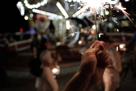 Hand with Sparkler. blurry sparks and background.close-up. party conceptの写真素材