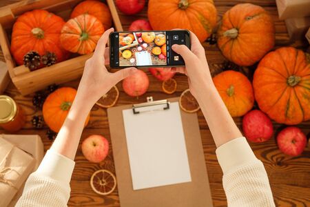 Smartphone food photography of vegetarian lunch or dinner. Woman hands taking phone photo of pumpkins in trendy style for social media or blogging.の写真素材