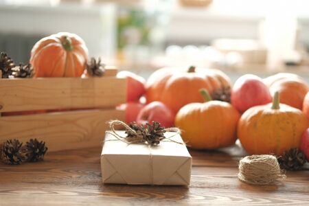 Gift boxes with pumpkins, garlands, apples and cones on a wooden table. Holiday, birthday, new year, christmas. Halloween holiday concept. holiday concept.の写真素材