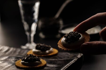 Sandwich with black sturgeon caviar on black background. Luxurious black caviar.の写真素材