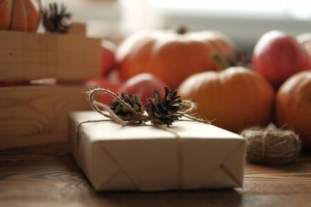 Gift boxes with pumpkins, garlands, apples and cones on a wooden table. Holiday, birthday, new year, christmas. Halloween holiday concept. holiday concept.の写真素材
