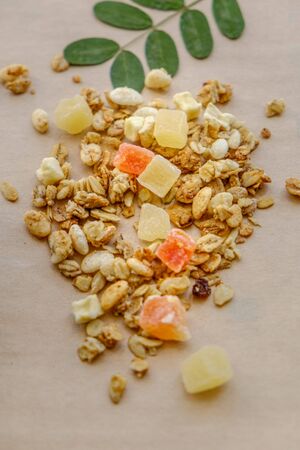 granola with candied fruit sprinkled on a wooden table. healthy eating conceptの写真素材