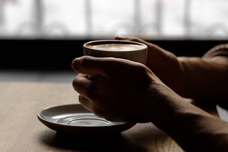 cup of cappuccino in the hands. close-up. soft lightの写真素材