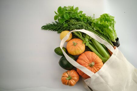 Fresh colorful organic vegetables coming out from eco shopping bag - captured from above (top view,...