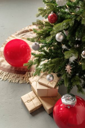 Gift boxes in recycled paper under the Christmas tree. Christmas background for greeting card. The...