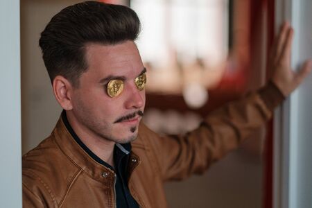 young man with bitcoins in the eye sockets. financier. business meeting. mafiaの写真素材