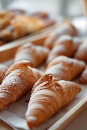 Many fresh croissants on a wooden tray. home bakery concept. Cafe. gluten free. top viewの写真素材