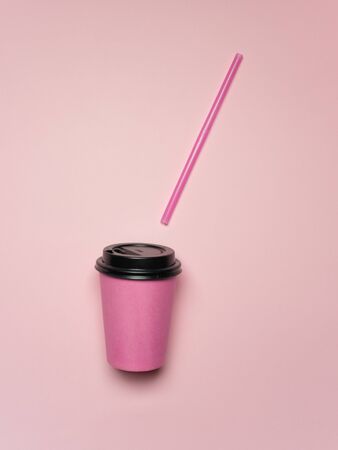 pink coffee cup with a plastic tube on a pink background. takeaway coffee concept. Eco friendly. Plastic dishes.の写真素材