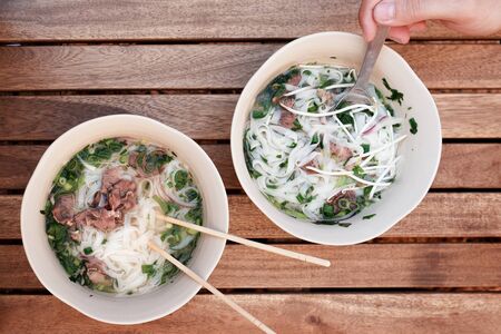 two plates of pho bo. Vietnamese soup pho bo. Panasian cuisine. Veal and Noodle Soupの写真素材