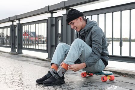 cheerful teenager sits on a penny board. Friendship, sport, youth.portrait. Sport lifestyle concept
