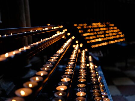 Burning candles in sconces on black blue backgroundの写真素材