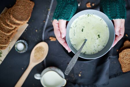 female hands hold a plate with soup in their hands. Winter food concept. Food for warming. Hot foodの写真素材