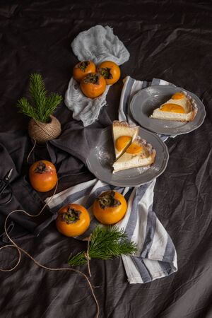 curd dessert with persimmon on a dark background. Vintage. Beautiful table setting.の写真素材