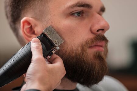 haircut beard typewriter. beard trimmer. Barber services. The man in the barbershop. Hipsterの写真素材