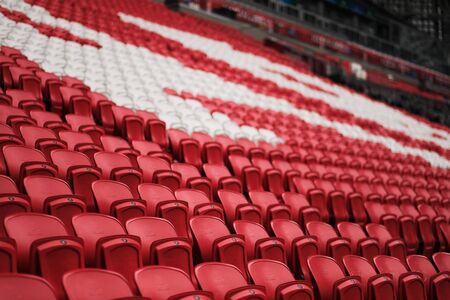 Empty red plastic seats in the stadium.