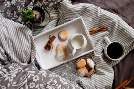 cozy flat ley in scandinavian style. Coffee with cookies in bed. read a book in bedの写真素材