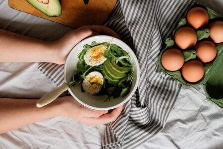 flat lay breakfast. Wholesome food, beautiful serving. Eggs, avocados and greens. top viewの写真素材