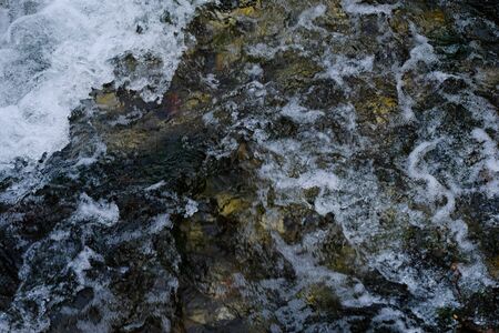 slow shutter speed, to show water flowing over rocks with ice formations. Flowing Water. Selective...