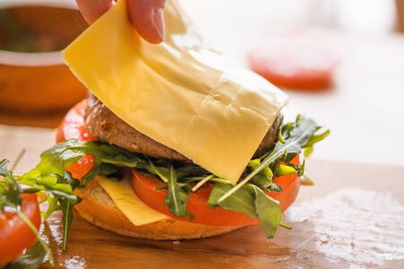 Preparation of burger. Cooking hamburger concept. Cook preparing burger adding meet. Cook adding...