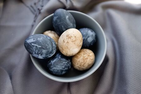 Easter background with Easter eggs in a ceramic gray bowl. Background with easter eggs. Naturally...
