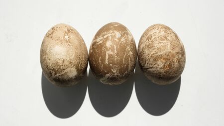 Naturally dyed eggs prepared for Easter on white background. Happy Easter card. Background with...