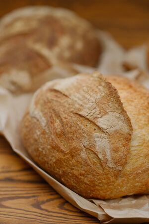 Different buns of fresh bread on a brown vintage background. Freshly baked wheat bread, still life...
