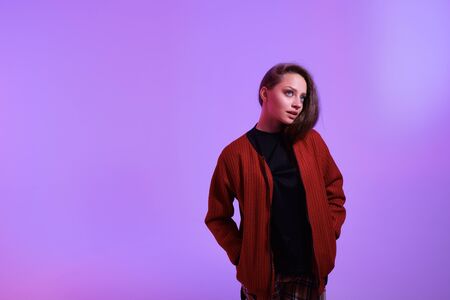 Attractive hipster girl on color background. Portrait of gorgeous female model posing in fashion...