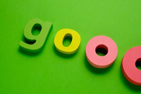 Word GOO made of color wooden letter, isolated on green background. Learning the English alphabet and the English language. The concept of child education, school, kindergarten,preschool educationの写真素材