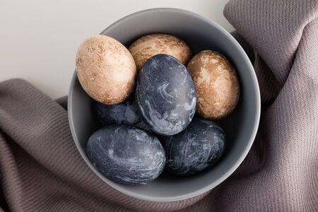 Naturally dyed eggs prepared for Easter on gray texture tablecloth background. Happy Easter. Easter...