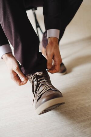 Grooms morning preparation.Handsome man getting dressed and preparing for the wedding.Friend helping groom getting ready in the room for wed day.の写真素材