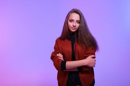 Attractive hipster girl on color background. Portrait of gorgeous female model posing in fashion color clothes in studio. The concept of stylish and sexy women, perfect skin and bodyの写真素材