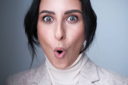A large portrait of an emotional middle-aged woman (30-35 years old) with dark hair and brown eyes...