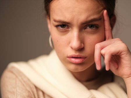 A close-up portrait of a beautiful young girl with brown hair and green eyes with natural makeup in...