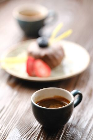 Little cup with espresso on a dark wooden table in a cafe. Tasty coffeeの写真素材