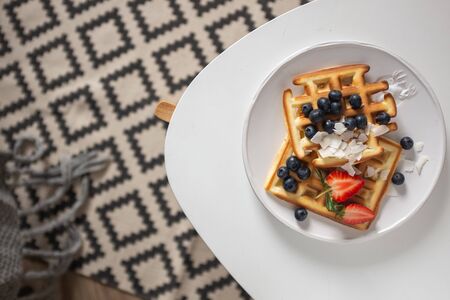 Beautiful breakfast: Viennese Belgian waffles decorated with berries, a plate with strawberries and...