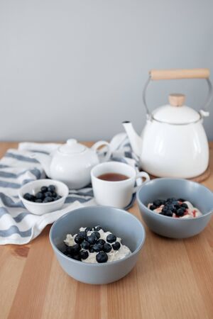 Tasty breakfast of Tvorog, farmers cheese, curd cheese or cottage cheese and blueberries in gray bowls. Rich in calcium healthy food. Healthy breakfast. Kinfolk style lifeの写真素材