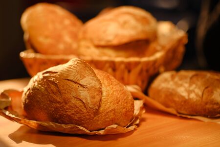 Different buns of fresh bread on a brown vintage background. Freshly baked wheat bread, still life with bread, crisp loaf of bread, rustic bread, loaf. Bread making business.の写真素材