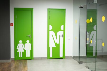 Bright green public toilet doors or WC, Restroom with man and woman glossy signs. Public toilet for children and public toilet for adultsの写真素材