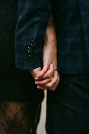 The newlyweds hold hands after the wedding ceremony. Hands of husband and wife with rings. Hands...