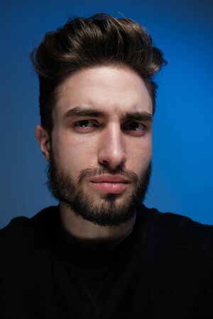 Beautiful caucasian young man portrait isolated on multicolored neon light backgroud. Young, smiling, surprised, screaming. Human emotions, facial expression concept. Trendy colors.Advertising conceptの写真素材