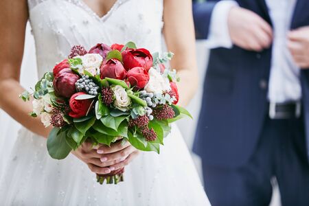 Bride holds a wedding bouquet, wedding dress, wedding details. Beautiful luxury wedding blog...