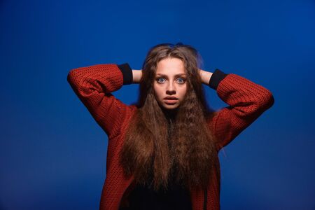 a young girl with blue eyes and blond long hair in a black T-shirt and red bomber jacket on a trendy...