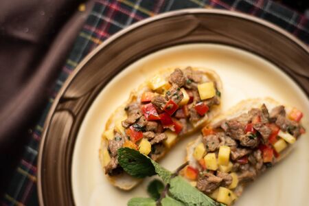 Open toasts with different toppings on a black background. Assortment of italian traditional bruschetta. Appetizing bruschetta.Variety of small sandwichesの写真素材