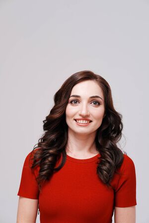 Studio portrait of woman in red dress on plain backgroundの写真素材