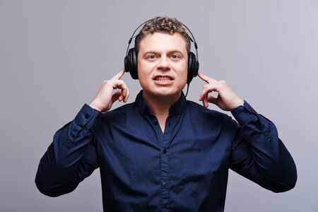 Studio portrait of a surprised rocker musician in headphonesThe concept of happiness, musicの写真素材