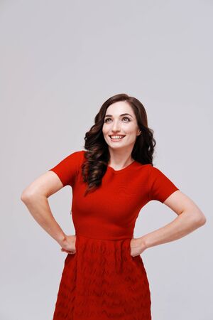 Studio portrait of woman in red dress on plain backgroundの写真素材
